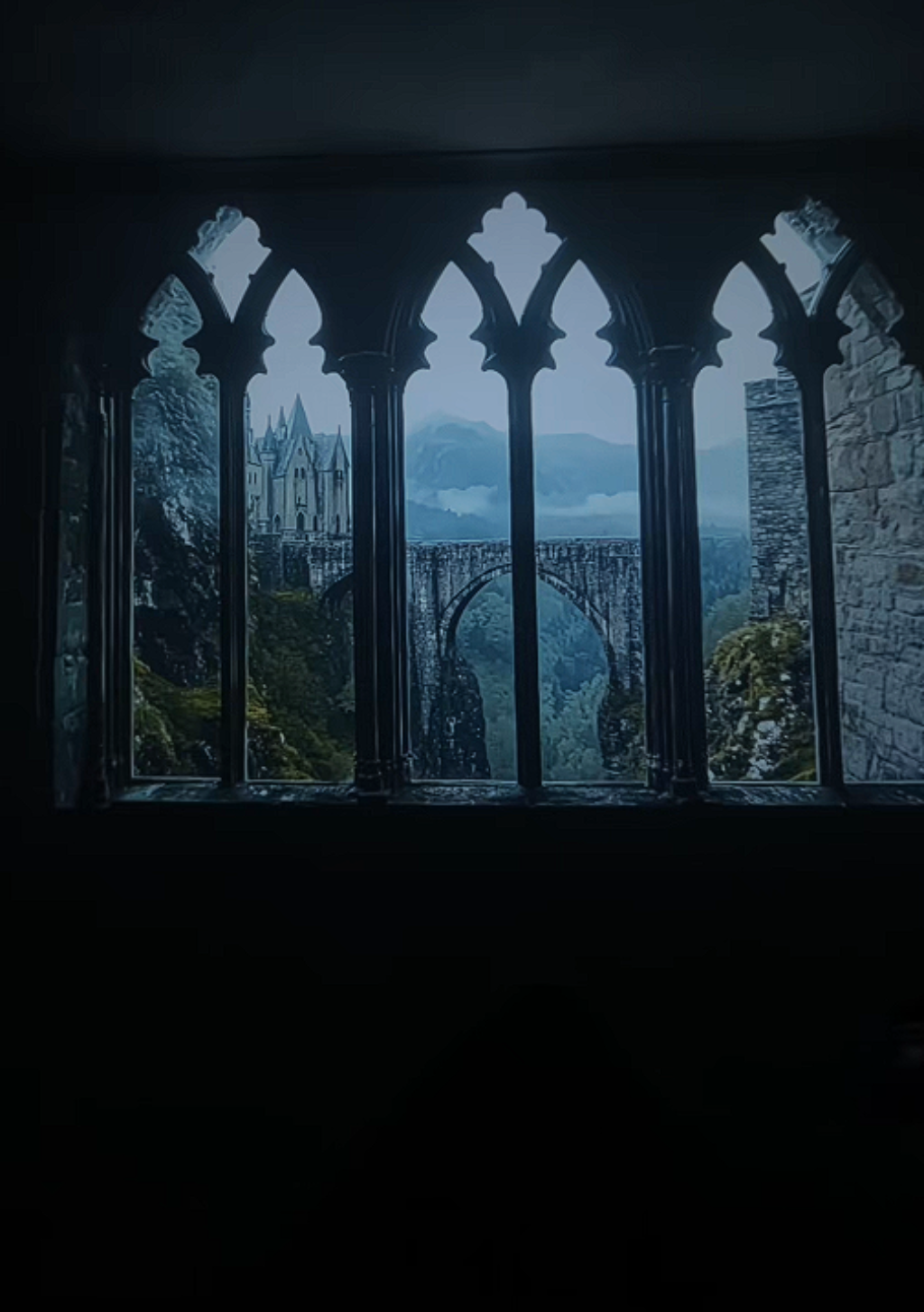 Castle view through gothic-style window with stone wall